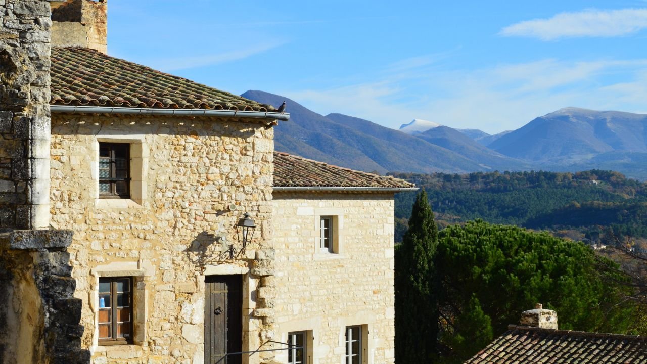 The Art of Drawing Readers In: Your attractive post title goes here Picturesque stone houses in a serene village setting with lush green hills and majestic mountains.