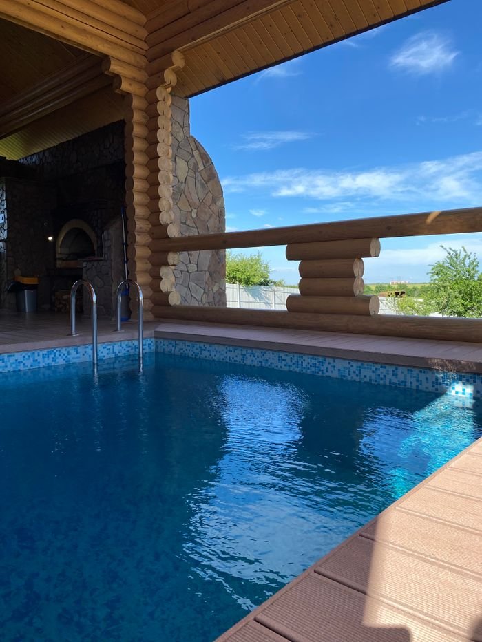 A serene indoor pool overlooking a clear blue sky and landscape.